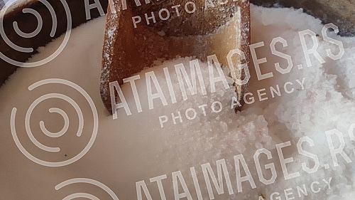 Wooden bowl with salt and spoon in it. So i kasika u drvenoj ciniji.