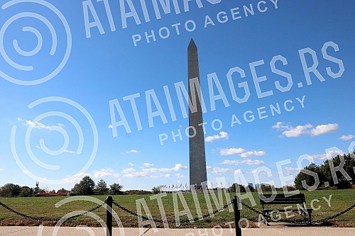 The Washington Monument, a monument to George Washington, the first President of the United States, is one of the most prominent landmarks in Washington and stands as a central part of the National Mall, and is surrounded by American flags. Vasingt