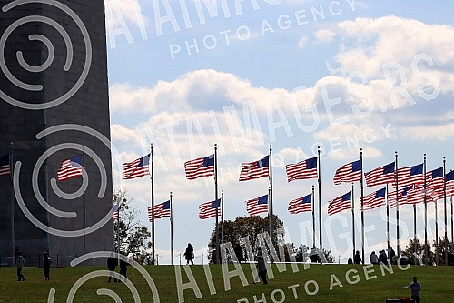 The Washington Monument, a monument to George Washington, the first President of the United States, is one of the most prominent landmarks in Washington and stands as a central part of the National Mall, and is surrounded by American flags. Vasingt