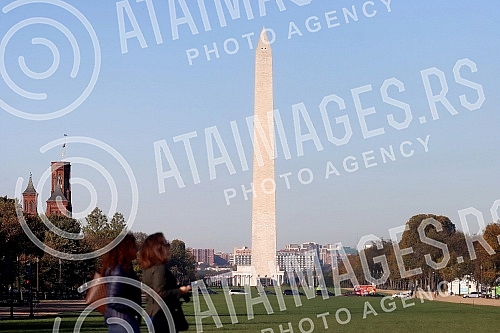The Washington Monument, a monument to George Washington, the first President of the United States, is one of the most prominent landmarks in Washington and stands as a central part of the National Mall, and is surrounded by American flags. Vasingt