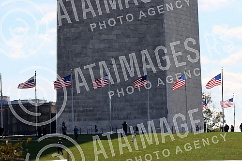 The Washington Monument, a monument to George Washington, the first President of the United States, is one of the most prominent landmarks in Washington and stands as a central part of the National Mall, and is surrounded by American flags. Vasingt