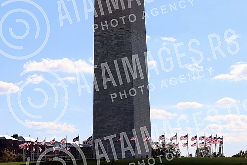 The Washington Monument, a monument to George Washington, the first President of the United States, is one of the most prominent landmarks in Washington and stands as a central part of the National Mall, and is surrounded by American flags. Vasingt