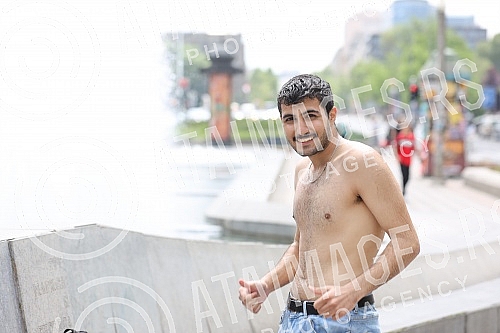 A migrant from Kuwait is bathing in a fountain on Nikola Pasic Square.Migrant iz Kuvajta se kupa u fontani na Trgu Nikole Pasica.